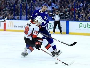 Ryan McDonagh #27 of the Tampa Bay Lightning and Ryan Dzingel #18 of the Ottawa Senators fight for the puck during a game  at Amalie Arena on March 13, 2018 in Tampa, Florida.
