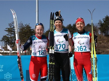 Posing for photos after the women's cross-country ski 1.5-kilometre classic sprint race are gold medallist Anna Milenina of Neutral Paralympic Athlete, silver medallist Vilde Nelsen of Norway and bronze medallist Natalie Wilkie of Canada.