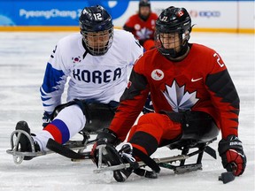Liam Hickey of Canada battles for the puck with Young Sung kim of Korea in the semifinals at the PyeongChang 2018 Paralympic Games on Wednesday, March 15, 2018.