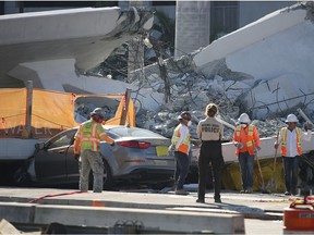 MIAMI, FL - MARCH 16:  Workers, law enforcement and members of the National Transportation Safety Board investigate the scene where a pedestrian bridge collapsed a few days after it was built over southwest 8th street allowing people to bypass the busy street to reach Florida International University on March 16, 2018 in Miami, Florida. Reports indicate that there are six fatalities as a result of the collapse.