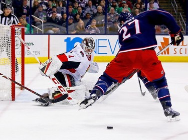 Senators goalie Mike Condon deflects the puck through the legs of Blue Jackets defenceman Ryan Murray after making a save on a shot in the second period of play.