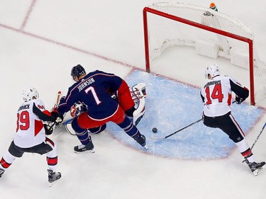 Alex Burrows of the Senators flips the loose puck past Blue Jackets netminder Sergei Bobrovsky for a goal during the first period.