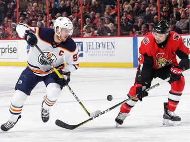 Connor McDavid #97 of the Edmonton Oilers chips the puck past Cody Ceci #5 of the Ottawa Senators in the first period at Canadian Tire Centre on March 22, 2018 in Ottawa.