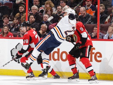 Milan Lucic #27 of the Edmonton Oilers falls to the ice after contact with Bobby Ryan #9 of the Ottawa Senators as teammate Filip Chlapik #78 looks on in the first period at Canadian Tire Centre on March 22, 2018 in Ottawa.