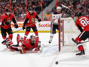 Craig Anderson #41 of the Ottawa Senators makes a save and is out of position as teammate Christian Wolanin #86 looks for the puck and Bobby Ryan #9 and Cody Ceci #5 of the Ottawa Senators and Milan Lucic #27 of the the Edmonton Oilers react in the first period at Canadian Tire Centre on March 22, 2018 in Ottawa.