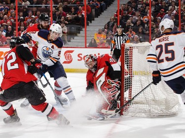 Craig Anderson #41 of the Ottawa Senators gets his paddle down for the save against Darnell Nurse #25 of the Edmonton Oilers as Thomas Chabot #72 of the Ottawa Senators and Ryan Nugent-Hopkins #93 of the Edmonton Oilers react in the first period at Canadian Tire Centre on March 22, 2018 in Ottawa.