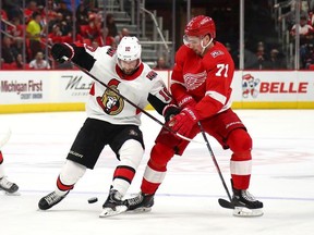 Dylan Larkin #71 of the Detroit Red Wings battles for the puck with Tom Pyatt #10 of the Ottawa Senators during the first period at Little Caesars Arena on March 31, 2018 in Detroit, Michigan.