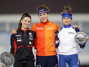 Ottawa's Ivanie Blondin, left, joins gold medallist Antoinette de Jong of Netherlands and bronze medallist Nathalia Voronina of Russia on the podium after the women's 3,000 metres at the World Cup speed skating finals in Minsk on Saturday.