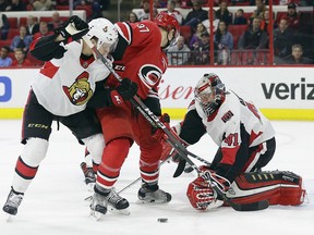 Carolina Hurricanes' Warren Foegele (37) tries to score against Ottawa Senators goalie Craig Anderson (41) while Senators' Thomas Chabot defends in Raleigh, N.C., Monday, March 26, 2018. (AP Photo/Gerry Broome)