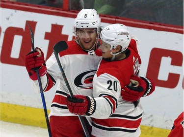 Carolina's Noah Hanifin (5) celebrates his third-period goal against the Senators with teammate Sebastian Aho.