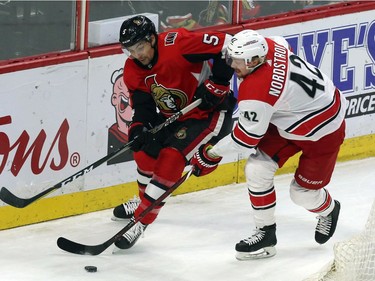 Ottawa's Cody Ceci (5) and Carolina's Joakim Nordstrom chase the puck during the second period of play.