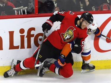 Ottawa Senators left wing Magnus Paajarvi (56) hits New York Islanders centre Mathew Barzal (13) during first period NHL hockey in Ottawa, Tuesday, March 27, 2018 .