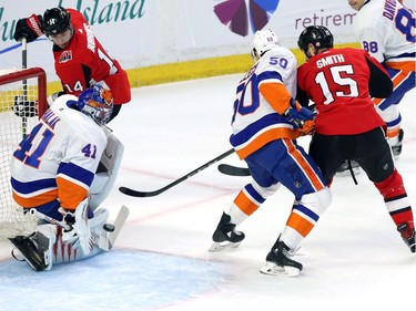 New York Islanders goaltender Jaroslav Halak (41) makes a save on Ottawa Senators right wing Alexandre Burrows (14) as New York Islanders defenceman Adam Pelech (50) and Ottawa Senators left wing Zack Smith (15) battle in front during first period NHL hockey in Ottawa, Tuesday, March 27, 2018.