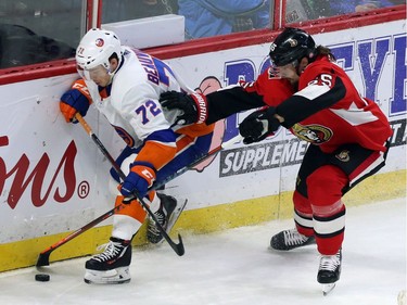 New York Islanders centre Anthony Beauvillier (72) and Ottawa Senators defenceman Erik Karlsson (65) battle for the puck during second period NHL hockey in Ottawa, Tuesday, March 27, 2018.