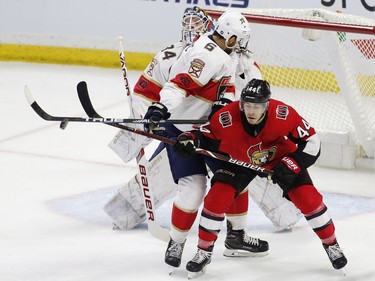 Ottawa Senators centre Jean-Gabriel Pageau (44) tries to tip the puck by Florida Panthers goaltender James Reimer (34) as defenceman Alexander Petrovic (6) defends.