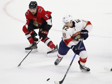 Ottawa Senators defenceman Cody Ceci tries to get the puck from Florida Panthers centre Denis Malgin.