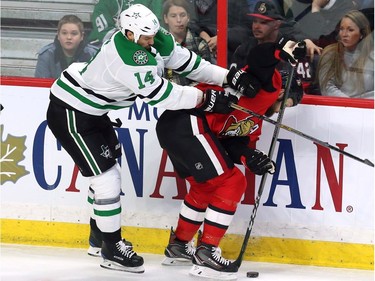 Senators forward Zack Smith (15) is checked by the Stars' Jamie Benn during second-period action.