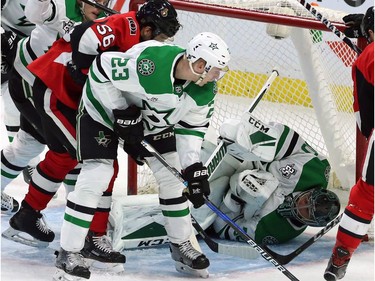 Stars netminder Ben Bishop smothers the puck to stop play as defenceman Esa Lindell (23) and Senators forward Magnus Paajarvi (56) look on during the second period.