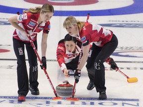 Canada's Jill Officer delivers a shot that is followed by third Kaitlyn Lawes, left, and lead Dawn McEwen at the World Women's Curling Championship in North Bay, Ont., Monday, March 19, 2018. (THE CANADIAN PRESS/Paul Chiasson)
