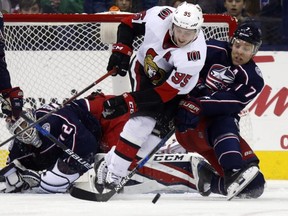 Senators forward Matt Duchene, centre, works for the puck between Blue Jackets goalie Sergei Bobrovsky, left, and defenceman Jack Johnson during second-period action.