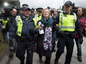 Federal Green Party Leader Elizabeth May, centre, is arrested by RCMP officers after joining protesters outside Kinder Morgan's facility in Burnaby, B.C., on Friday March 23, 2018. THE CANADIAN PRESS/Darryl Dyck