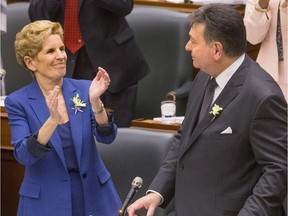 Ontario's Premier Kathleen Wynne applauds Provincial Finance Minister Charles Sousa as the Ontario Provincial Government delivers its 2018 Budget , at the Queens Park Legislature.