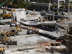 Crushed cars lie under a section of a collapsed pedestrian bridge near Florida International University in the Miami area on Friday.