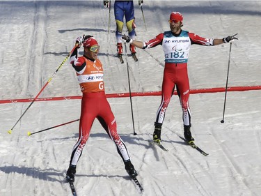 Canada's Brian Mckeever, right, and guide Russell Kennedy celebrate after winning the men's 1.5-kilometre sprint classic visually impaired cross-country ski race on Wednesday.