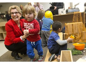 Ontario premier Kathleen Wynne plays with Reese Prineau as she tours the White Oaks Family Centre before announcing the launch of Ontario Early Years Child and Family Centres at the Bradley Avenue pre school in London, Ont. on Friday February 19, 2016.