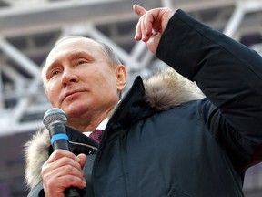 Russian President Vladimir Putin gestures while speaking during a massive rally in his support as a presidential candidate at the Luzhniki stadium in Moscow, Russia, Saturday, March 3, 2018.