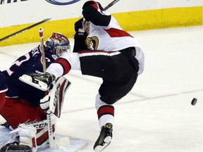 Ottawa Senators forward Ryan Dzingel, right, reacts after being hit on the head by the puck in front of Columbus Blue Jackets goalie Sergei Bobrovsky, of Russia, during the third period of an NHL hockey game in Columbus, Ohio, Saturday, March 17, 2018.