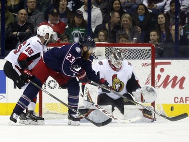 Senators goalie Mike Condon makes a save despite an attempt to tip the shot by the Blue Jackets' Ian Cole in the first period.