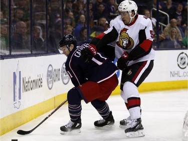 Blue Jackets forward Matt Calvert protects the puck while trying to hold off Senators defenceman Cody Ceci in the second period of Saturday's game.