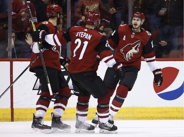 Coyotes defenceman Oliver Ekman-Larsson celebrates his goal against the Senators with centre Derek Stepan (21) and left-winger Brendan Perlini, left, during the first period.