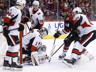 Despite the presence of Senators players Jean-Gabriel Pageau, left, Thomas Chabot (72) and Erik Karlsson, Coyotes winger Jordan Martinook scores a goal against netminder Mike Condon during the second period of play. It turned out to be the game-winner.