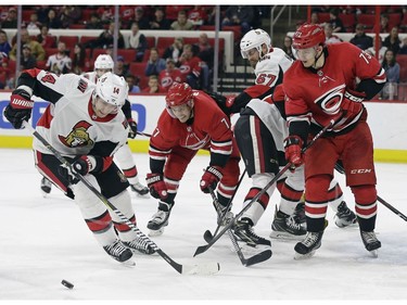 Ottawa Senators' Alexandre Burrows (14) skates against Carolina Hurricanes' Derek Ryan (7) and Valentin Zykov (73), of Russia, during the second period of an NHL hockey game in Raleigh, N.C., Monday, March 26, 2018.