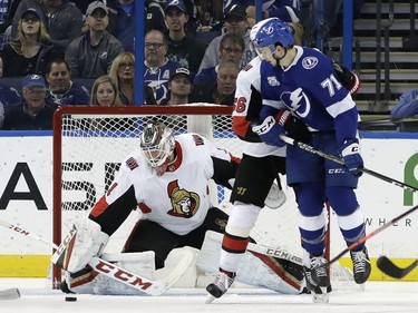 Ottawa Senators goaltender Mike Condon (1) makes a save on a deflection by Tampa Bay Lightning center Anthony Cirelli (71) during the first period of an NHL hockey game Tuesday, March 13, 2018, in Tampa, Fla.