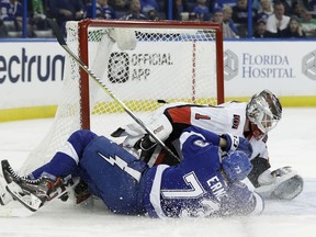 Senators goalie Mike Condon feels the crunch of a sliding Adam Erne of the Lightning during Tuesday night's game in Tampa, Fla.