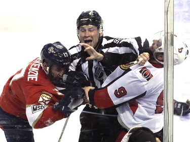 Linesman Mark Shewchyk (92) intervenes in an altercation between Florida Panthers' Derek MacKenzie, left, and Ottawa Senators' Bobby Ryan (9) during the third period of an NHL hockey game, Monday, March 12, 2018, in Sunrise, Fla.