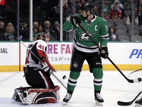 Senators goalie Craig Anderson locates the puck through a screen by the Stars' Jamie Benn and makes a save during Monday's game in Dallas.