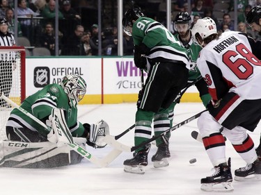 Dallas Stars goalie Kari Lehtonen, left, of Finland, and center Tyler Seguin (91) defend against pressure from Ottawa Senators left wing Mike Hoffman (68) in the second period of an NHL hockey game in Dallas, Monday, March 5, 2018.
