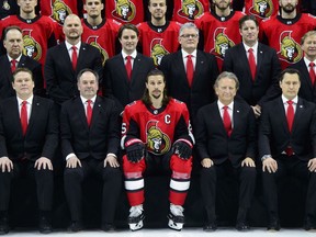 NHL Ottawa Senators captain Erik Karlsson sits alongside team owner Eugene Melnyk, second from left, as they take part in the annual team photo in Ottawa on Wednesday, March 7, 2018.THE CANADIAN PRESS/Sean Kilpatrick ORG XMIT: SKP103