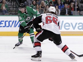 Dallas Stars right wing Brett Ritchie (25) advances the puck as Ottawa Senators defenseman Erik Karlsson (65) of Sweden defends in the first period of an NHL hockey game in Dallas, Monday, March 5, 2018. Karlsson later scored the winner. The Associated Press