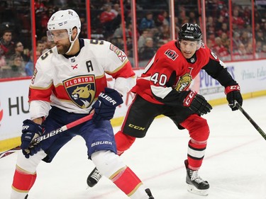 Jim O'Brien (R) skates behind Aaron Ekblad as he looks for the loose puck in the first period as the Ottawa Senators take on the Florida Panthers in NHL action at the Canadian Tire Centre in Ottawa.  Photo by Wayne Cuddington/ Postmedia
