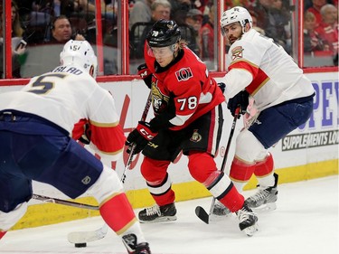 Filip Chlapik tries to work around Aaron Ekblad (L) and Keith Yandle (R) in the first period as the Ottawa Senators take on the Florida Panthers in NHL action at the Canadian Tire Centre in Ottawa.  Photo by Wayne Cuddington/ Postmedia