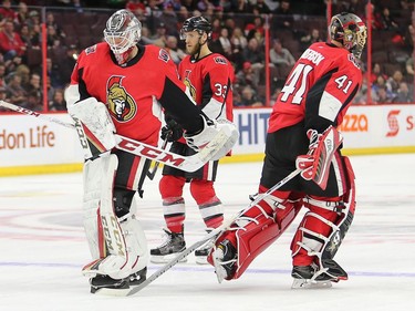 Mike Condon (L) and Craig Anderson pass as Anderson is pulled in the second period as the Ottawa Senators take on the Florida Panthers in NHL action at the Canadian Tire Centre in Ottawa.  Photo by Wayne Cuddington/ Postmedia