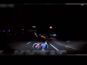 This screengrab of a video released by Tempe Police shows a woman with her bike walking across the street the moment an Uber self-driving vehicle hit her. (Tempe Police/Twitter)