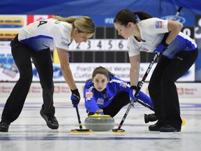 United States skip Jamie Sinclair delivers a stone as lead Monica Walker (right) and second Vicky Persinger sweep against Canada during the semifinal at the World Women's Curling Championship in North Bay, Ont., Saturday. (THE CANADIAN PRESS)