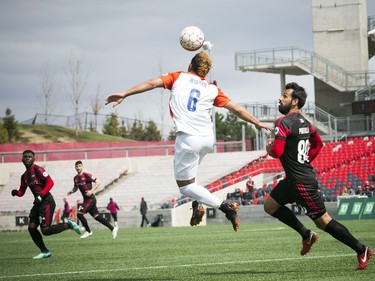 Cincinnati FC #6 Kenney Walker heads the ball as Ottawa Fury FC's #80 Cristian Portilla chases Saturday April 28, 2018 at TD Place.   Ashley Fraser/Postmedia