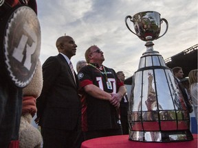 CFL Commissioner, Jeffrey Orridge, left, and Ottawa Redblacks owner, OSEG Sports President, Jeff Hunt, center stand by the Grey Cup after the announcement that Ottawa will host the 2017 CFL Grey Cup game at TD Place Arena in Ottawa Sunday, July 31, 2016. (Darren Brown/Postmedia) Neg 123738